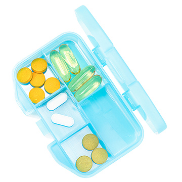A medication container is open showing different types of medicine