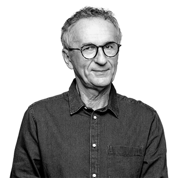individual wearing glasses with hands clasped