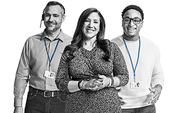 Three people from Team Blue stand smiling wearing badges and headsets