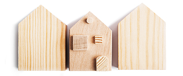 Three pieces of wood cut to shape the outline of houses